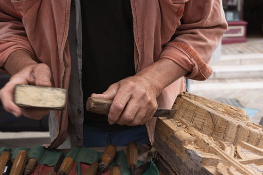 a man makes products from a tree with his own hands and with a tool close-up of a hand a tree. High quality photo