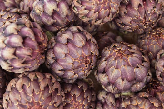 a lot of artichokes close-up. Artichokes are sold on a showcase, healthy food. High quality photo