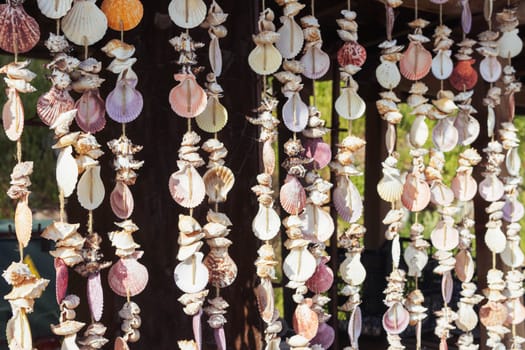 pendants with multi-colored shells are made by hand, they hang in the store for sale. High quality photo