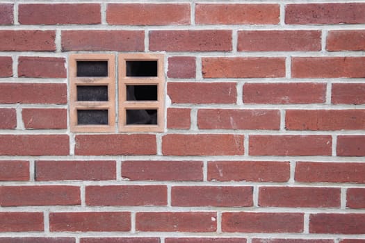 a wall with red small bricks with an extractor hood in the wall, a background for a screensaver with a place for an inscription. High quality photo