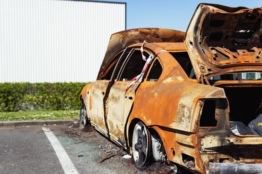 a burned-out car in the parking lot near the visa shop at the back of one half, there is a place for an inscription. Car insurance against fire. High quality photo