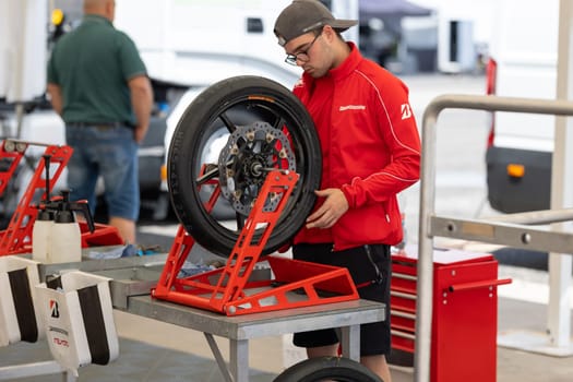 6 may 2023, Estoril, Portugal - MotoGP racing - A man working on a motorcycle tire in a garage