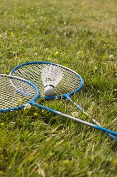 Badminton - shuttlecock on rackets on badminton courts on green grass. High quality photo