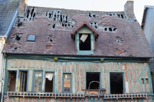 an old house with wooden walls and a roof full of holes, old tiles. Restoration of the building. High quality photo antique building in the old town, France