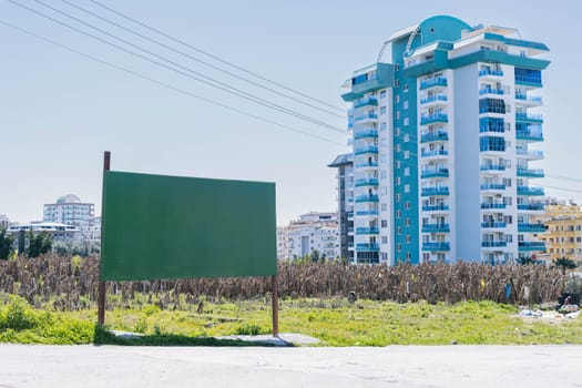 Banner on the street on the road for advertising there is a place for an inscription on the background. Hardware stands a multi-storey house. High quality photo