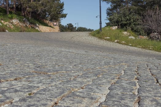 the road from the pavement is old in the city. There are green trees around, there is a place for an inscription. High quality photo