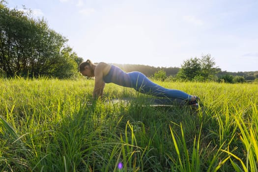 a girl of European appearance, goes in for sports outdoors at sunset in the park. The girl is dressed in a blue suit for fitness. The concept of sports and a healthy lifestyle. High quality photo