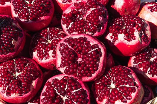 a lot of ripe red pomegranates with a cut off top, close-up background, space for an inscription. High quality photo