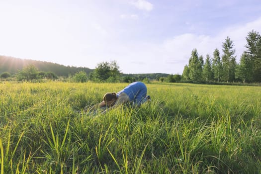 girl in a blue suit for fitness in the fresh air at sunset in the park goes in for sports, stands in the bar. There is green grass,the landscape is beautiful. The concept of sports. High quality photo