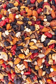 Background of mixed nuts and raisins. Healthy snack and food. Cashews, almonds, raisins, walnuts, pistachios. View from above. Assorted nuts and dried grapes. High quality photo