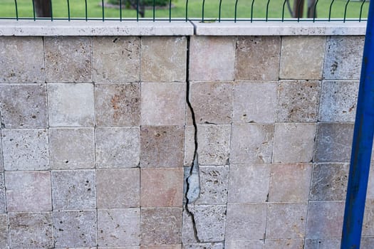 cracked old wall with tiles on the street The cracks are waiting to be repaired. High quality photo