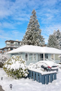 Winter season in residential area. Residential house in snow with a car parked on driveway