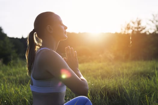 young girl doing yoga outdoors in a suit for fitness. The concept of a healthy lifestyle. there is a place for an inscription. High quality photo