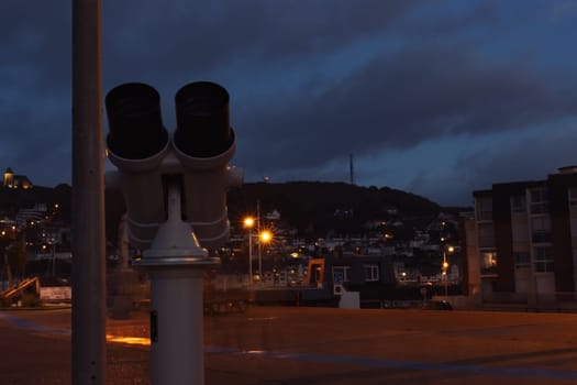 stationary binoculars close-up isolated on the background of the evening city lanterns shine. There is a place for an inscription. High quality photo