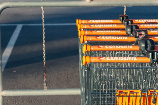 Many rows of orange trolleys outside the store with a close-up of the parking lot, there is a place for an inscription. Spain, Torrevieja shop Consum , August 10, 2023 High quality photo