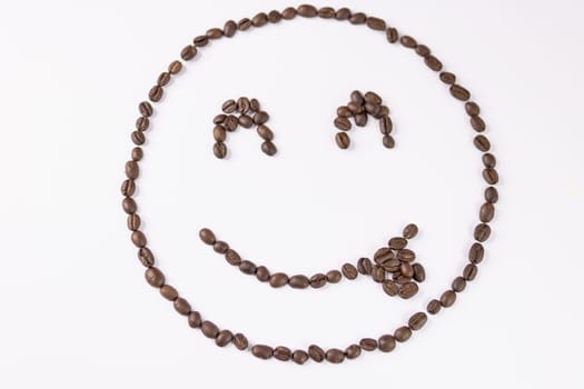 Roasted coffee beans background.Cheerful smiley with coffee beans on a white background. High quality photo