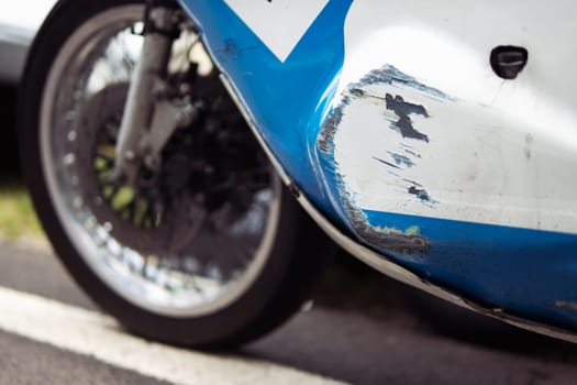 side view photo of a bumper scratched from a racing car close-up of a white-blue color. High quality photo