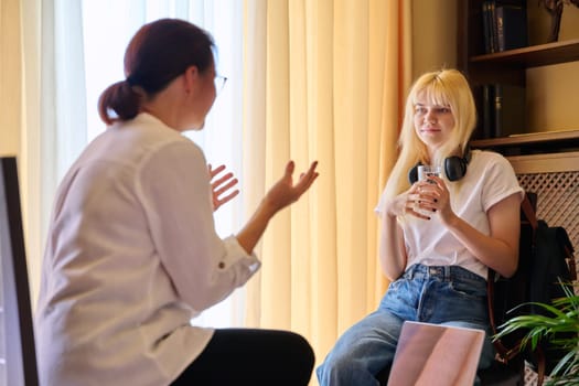 Teenage female in therapy session in psychologist's office, young woman talking about problems. Psychology, mental health, psychiatry, care, youth concept.