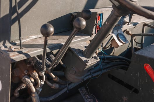 Detail of the interior of an old tractor in an industrial environment.close-up on the levers inside the loader. High quality photo