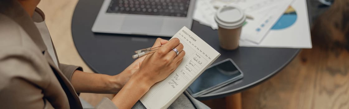 Female manager is making notes during meeting with colleague in coworking space