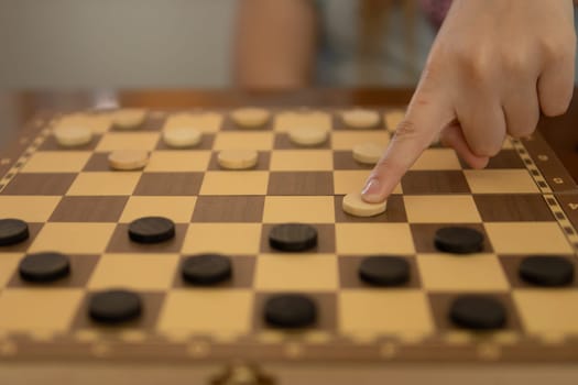 close-up of a girl's hand playing checkers, non-lectual games for a teenager. High quality photo