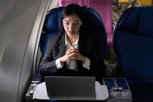Beautiful Asian businesswoman working with laptop in aeroplane. working, travel, business concept.