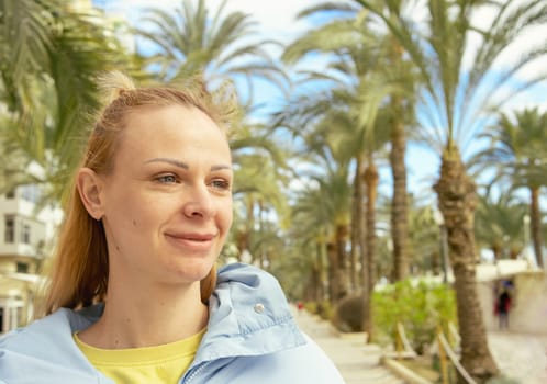 portrait of a girl on the embankment around the palm tree. High quality photo