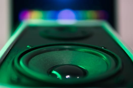 sound speaker in green neon light.Powerful music,blurred background. High quality photo