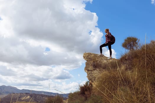 young woman hiker enjoy the view at mountain peak cliff,a beautiful landscape of nature. High quality photo