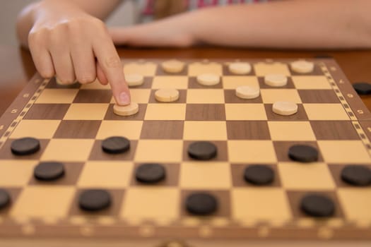 a game of checkers, a woman's hand close-up plays checkers, there is a place for an inscription. High quality photo