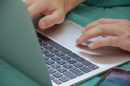 man typing on laptop hands on keyboard closeup freelancing concept. High quality photo