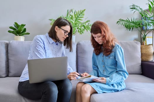 Individual lesson of teacher and child of preteen girl. Young woman teaching child, using laptop, student makes notes in notebook. Knowledge, education, teaching, tuition, school childhood concept