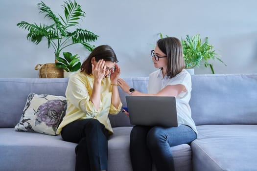 Middle aged woman in individual therapy, female psychologist and patient sitting together on couch in office. Psychology, counseling, psychotherapy, mental health, health care, mature people concept