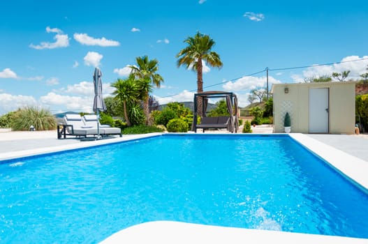 beautiful summer landscape with a swimming pool and palm trees, there is a place for an inscription. High quality photo