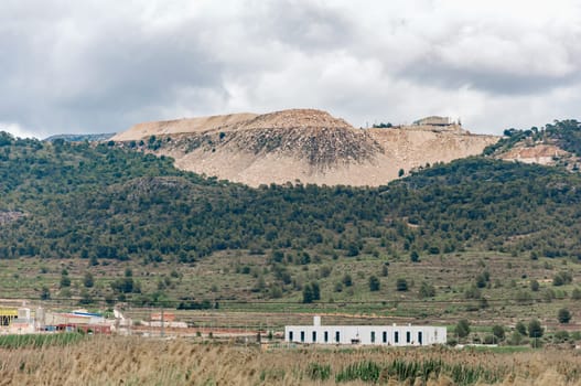 view of an open pit marble quarry showing heavy duty equipment and rock. High quality photo