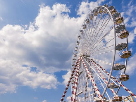 Ferris wheel in the city,a close-up view from the bottom against the blue sky.on the left there is a place for the inscription. High quality photo