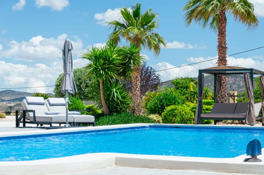 beautiful summer landscape with a swimming pool and palm trees, there is a place for an inscription. High quality photo