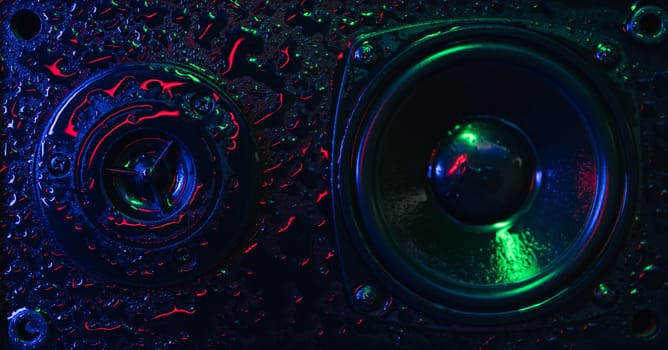 concept of powerful sound speakers in colorful neon light with water drops on the speaker. powerful music. High quality photo