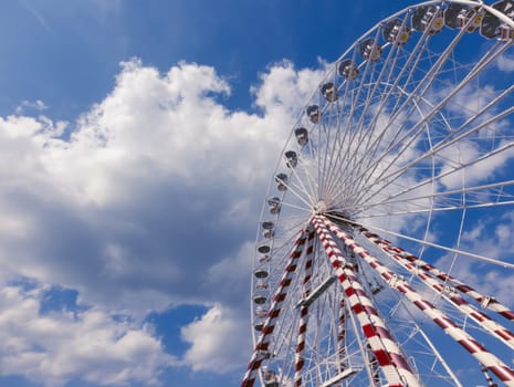 Ferris wheel in the city,a close-up view from the bottom against the blue sky.on the left there is a place for the inscription. High quality photo