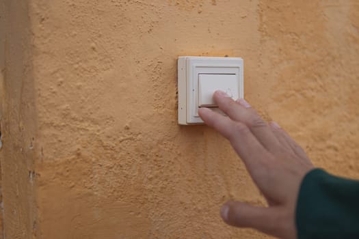 Female hand presses the doorbell button on the street close-up .there is a place for the inscription. High quality photo