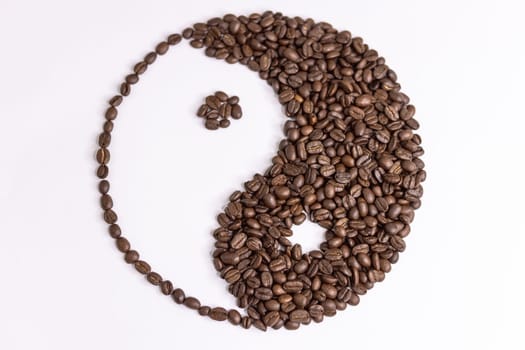 yin yang sign made by coffee beans on white background. High quality photo