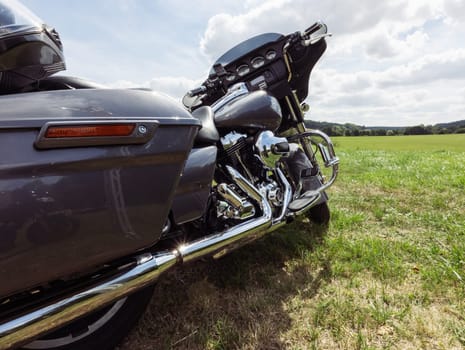 black motorcycle side view close-up ,motorbike stands on green grass isolated. High quality photo