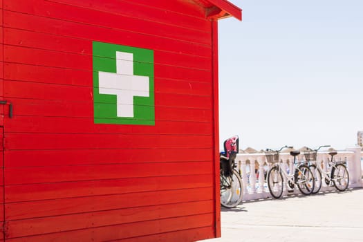 Center for Medical Assistance. Door with a cross. A small medical center for first aid on the beach. High quality photo