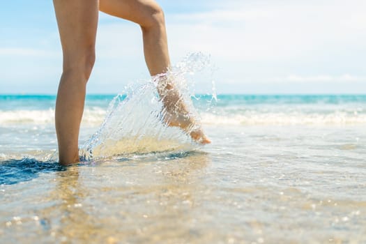 close-up of female legs walk on the water on the beach, there is a place for an inscription, a seascape. High quality photo