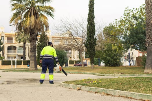 a girl in uniform cleans the streets with street cleaning equipment, a worker cleans the streets. High quality photo