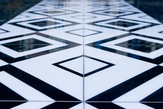 Builders laying tiles, new black and white tiles on the floor in the kitchen. Renovation concept. High quality photo