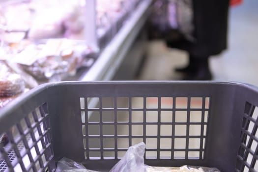 Gray shopping trolley in a supermarket or grocery store close-up with a blurred background. High quality photo