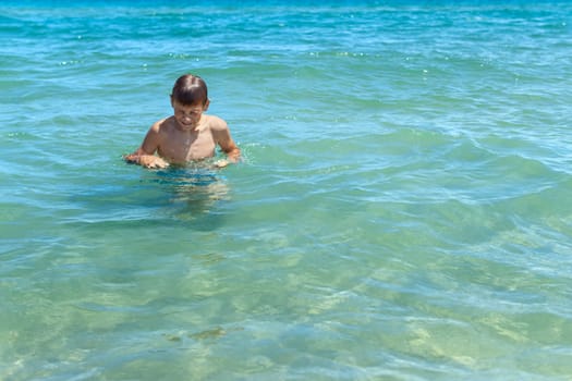 Happy boy swims and dives underwater. Active healthy lifestyle, water sports and activities with parents on summer family vacation with child. High quality photo