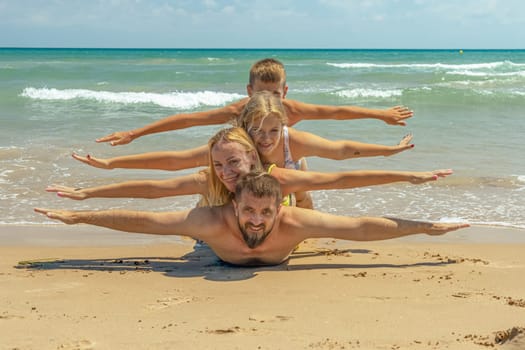 happy family takes a creative photo on the seashore, mom, dad and two children take a photo on the seashore. High quality photo