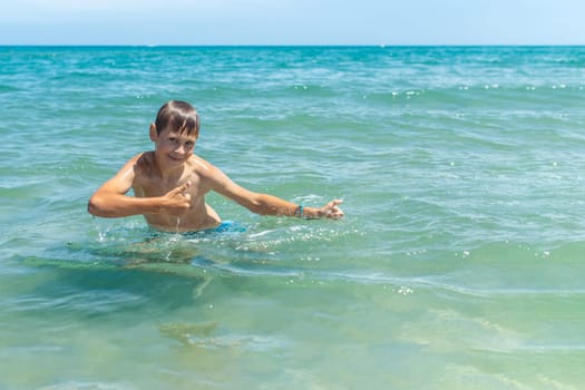 Happy boy swims and dives under water Active healthy lifestyle, water sports, seascape with a child there is a place for an inscription. High quality photo